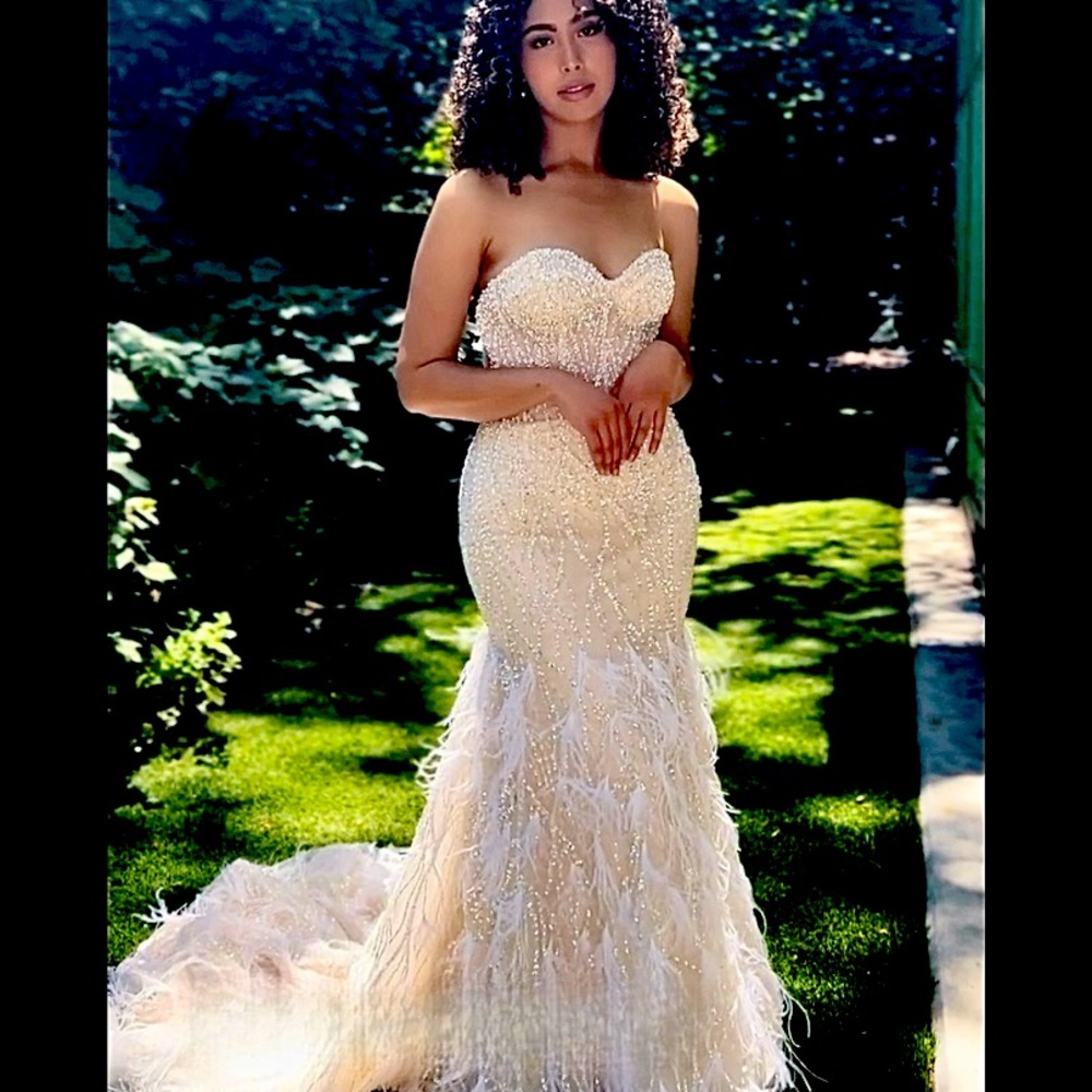 Glamorous unique fitted bridal gown with beading and feathers